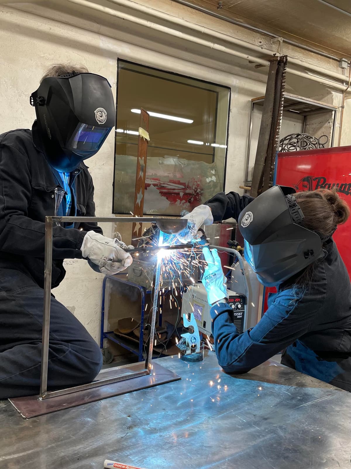 Zwei Personen schweissen gemeinsam an ihrer Metallkonstruktion