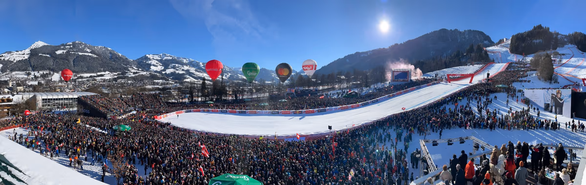 Panoramablick auf die Rennstrecke und die begeisterten Zuschauermassen beim Hahnenkamm-Rennen in Kitzbühel.