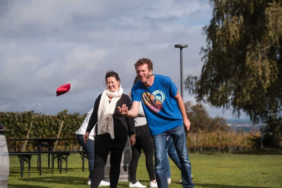 Teilnehmende bei der BITOU-Teamolympiade im Freien: Wurfspiel im Team.