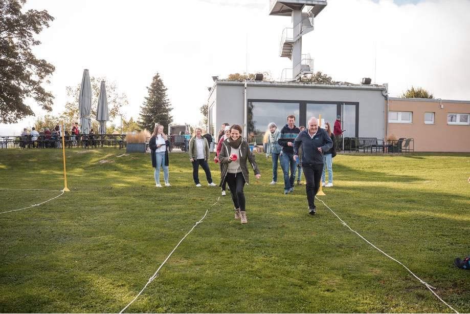 Teilnehmende bei der BITOU-Teamolympiade im Freien: Teamparcours auf der Wiese.