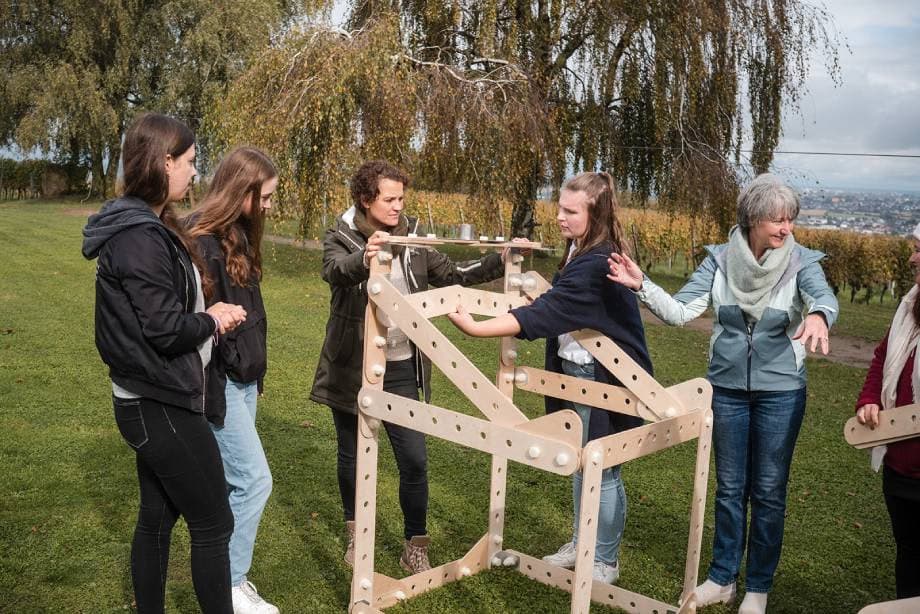 Teilnehmende bauen gemeinsam ein Windrad beim BITOU-Teamevent: Rahmen bauen.